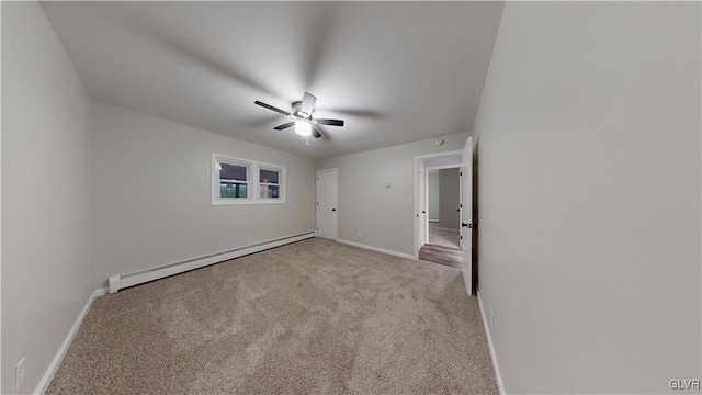 carpeted spare room featuring baseboard heating and ceiling fan