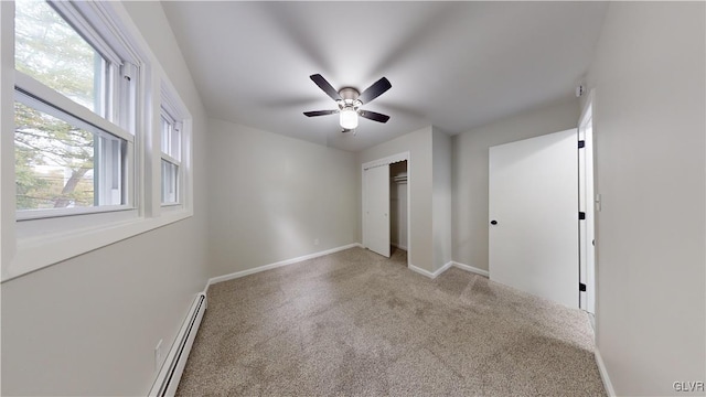 unfurnished bedroom with light carpet, a baseboard heating unit, a closet, and ceiling fan