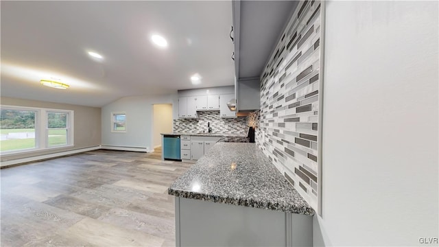 kitchen with dishwasher, gray cabinetry, decorative backsplash, a baseboard heating unit, and light hardwood / wood-style flooring