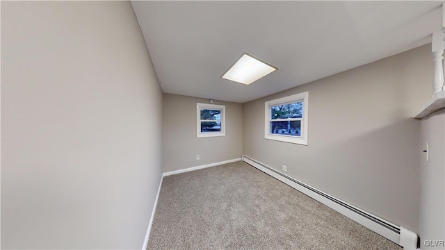 empty room featuring carpet and a baseboard heating unit