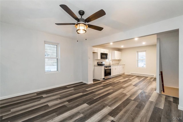 unfurnished living room featuring ceiling fan, dark hardwood / wood-style floors, sink, and baseboard heating