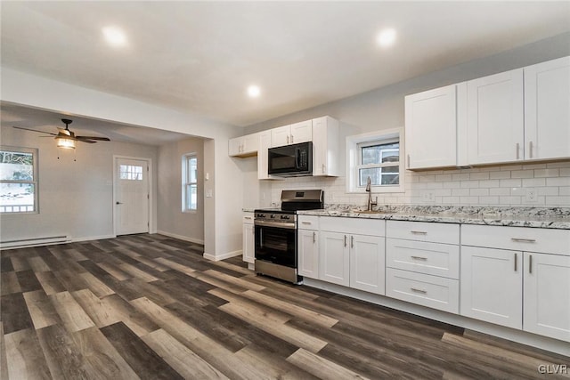 kitchen with sink, stainless steel gas range, a baseboard heating unit, white cabinets, and decorative backsplash