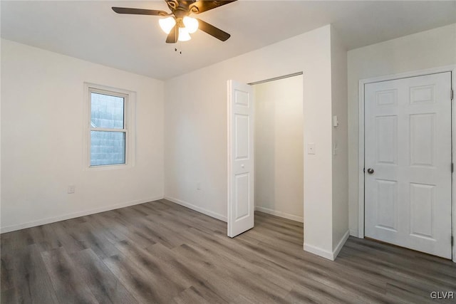 unfurnished bedroom featuring dark wood-type flooring and ceiling fan