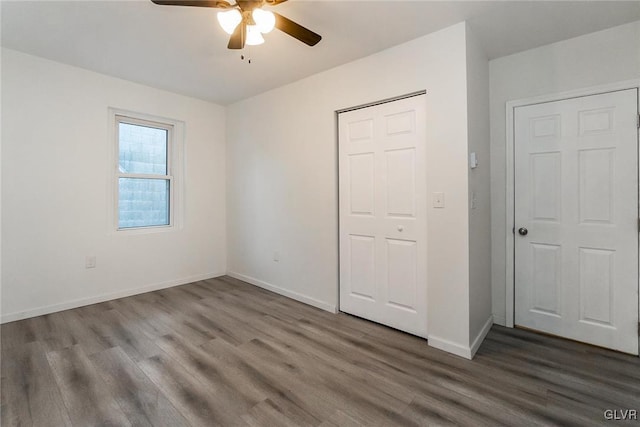 unfurnished bedroom featuring dark wood-type flooring and ceiling fan