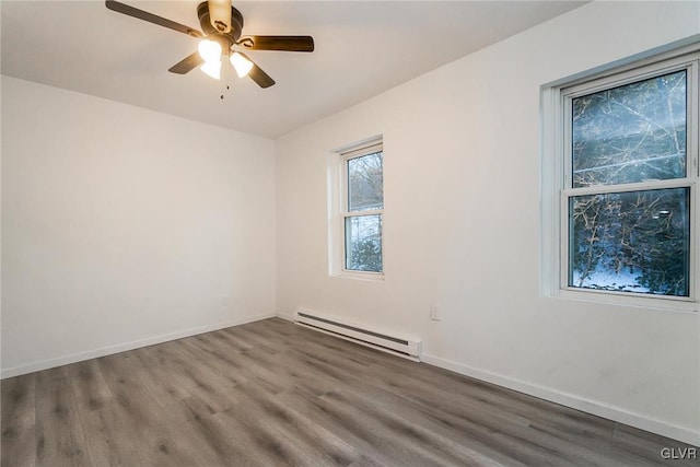 empty room featuring ceiling fan, a baseboard radiator, and wood-type flooring