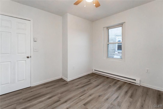 spare room featuring ceiling fan, hardwood / wood-style floors, and a baseboard heating unit