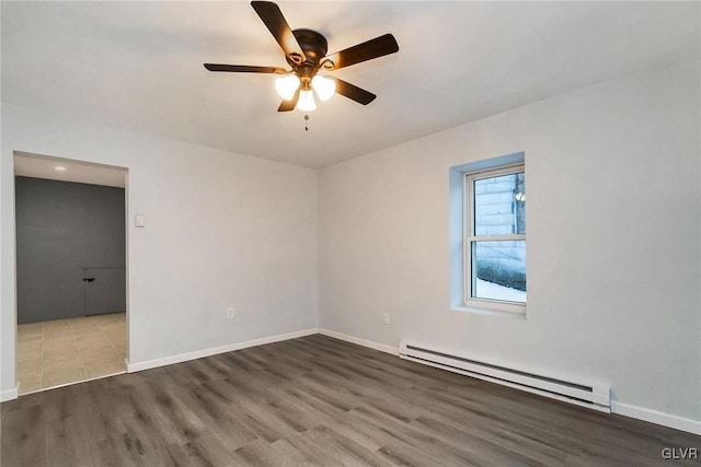 spare room featuring baseboard heating, ceiling fan, and wood-type flooring