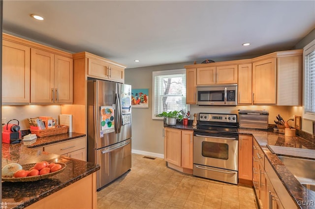 kitchen with stainless steel appliances, sink, and light brown cabinetry