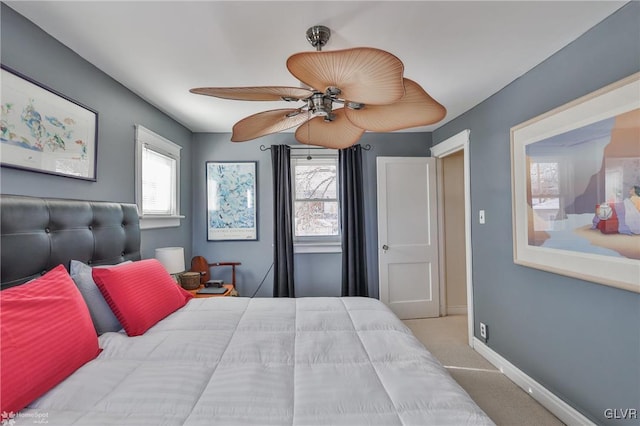 bedroom featuring ceiling fan, light colored carpet, and multiple windows