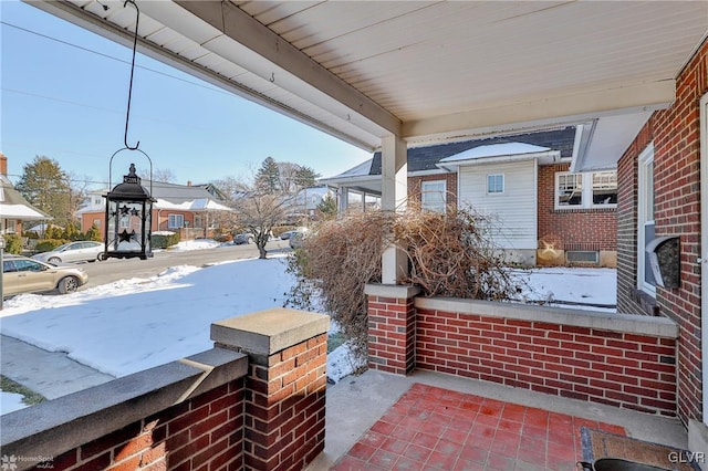 snow covered patio with a porch