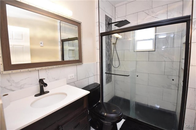 bathroom featuring tasteful backsplash, vanity, toilet, and a shower with door