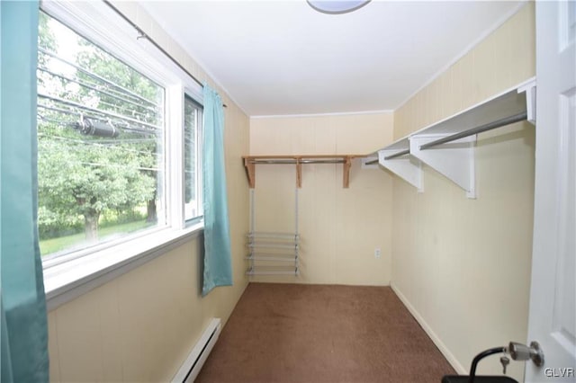 spacious closet with baseboard heating and dark colored carpet