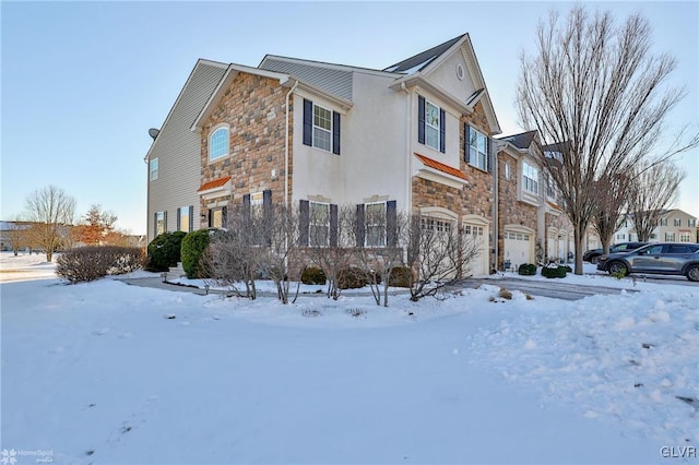 snow covered property featuring a garage