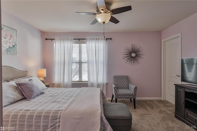 bedroom with multiple windows, ceiling fan, and light carpet