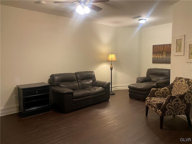 living room with dark wood-type flooring and ceiling fan