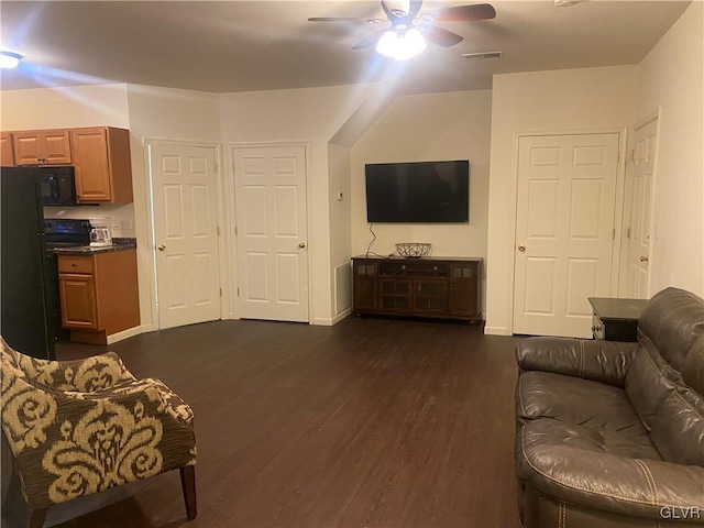 living room featuring ceiling fan and dark hardwood / wood-style floors