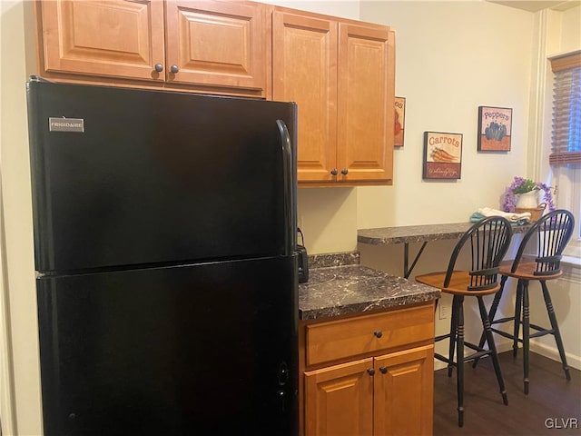 kitchen featuring black refrigerator and dark wood-type flooring