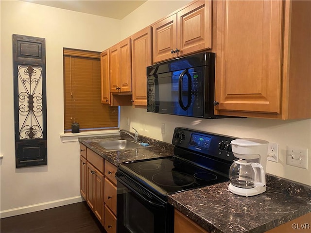 kitchen featuring sink, dark stone counters, and black appliances