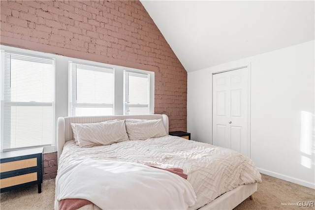 bedroom with vaulted ceiling, brick wall, and light carpet