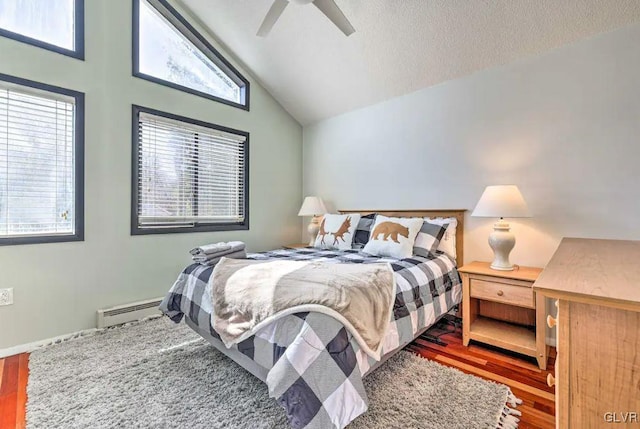 bedroom featuring lofted ceiling, a textured ceiling, a baseboard radiator, ceiling fan, and hardwood / wood-style floors