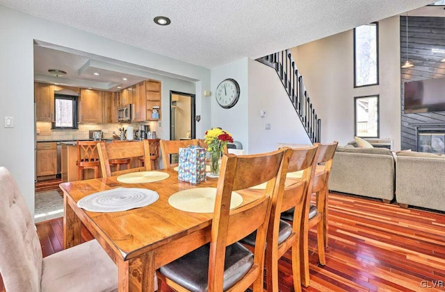 dining room with light hardwood / wood-style floors, a textured ceiling, and a wealth of natural light