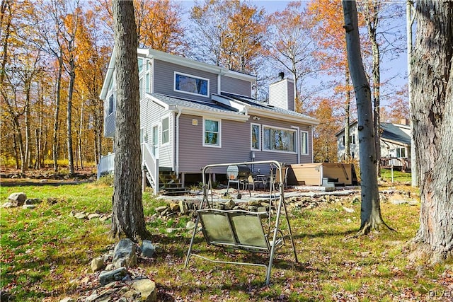 rear view of house featuring a hot tub