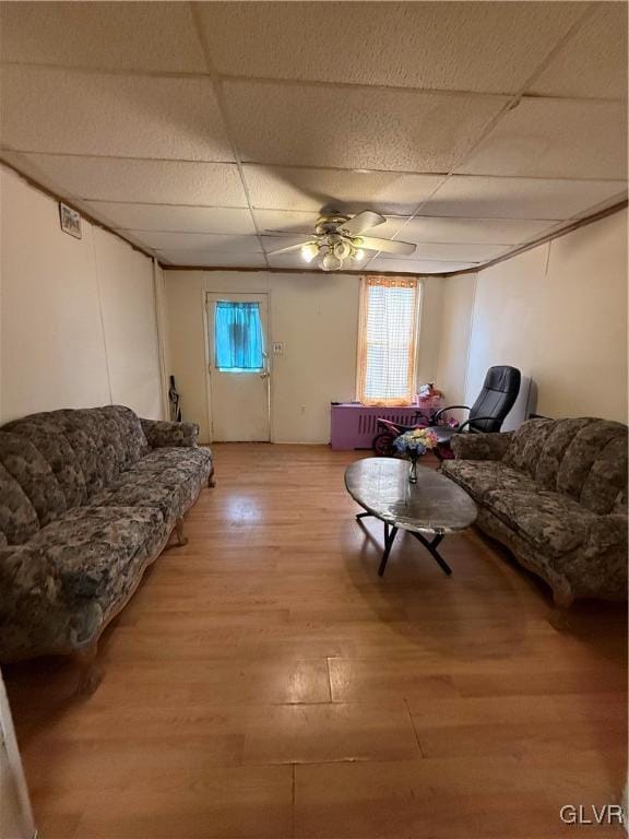 living room with ceiling fan, hardwood / wood-style floors, and a drop ceiling