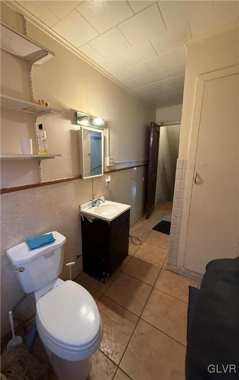 bathroom featuring vanity, crown molding, tile patterned floors, and toilet