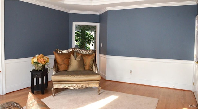 living area with hardwood / wood-style floors and ornamental molding