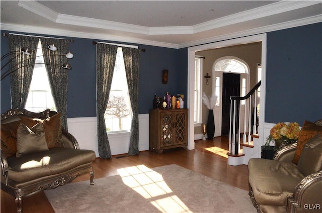 sitting room featuring hardwood / wood-style flooring, ornamental molding, and a healthy amount of sunlight