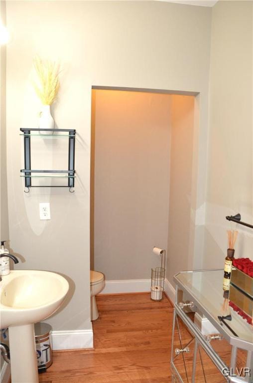 bathroom with hardwood / wood-style flooring and toilet