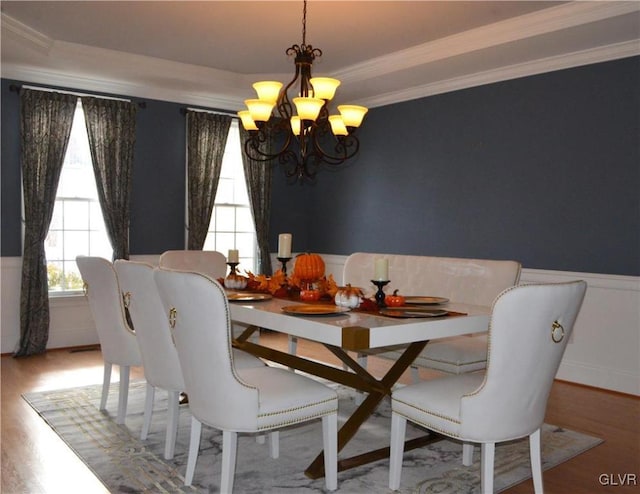 dining area featuring hardwood / wood-style flooring, ornamental molding, and a chandelier