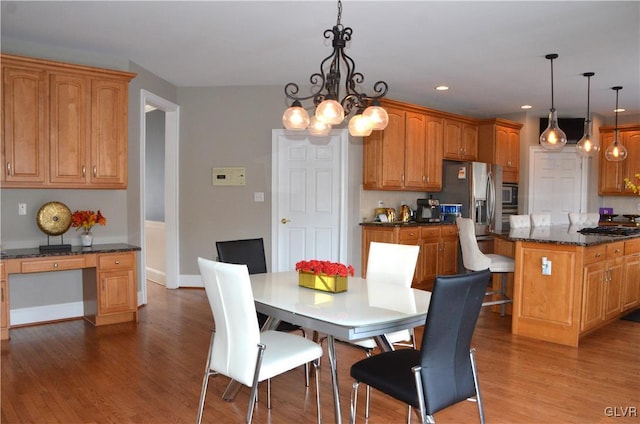 dining room with hardwood / wood-style flooring, built in desk, and a chandelier