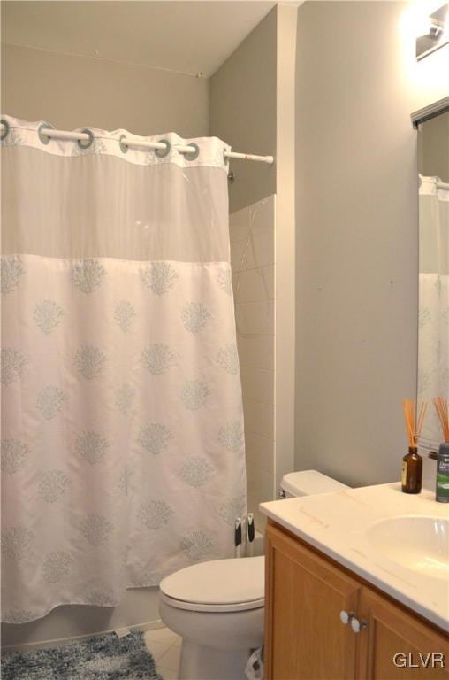 bathroom featuring a shower with curtain, vanity, toilet, and tile patterned flooring