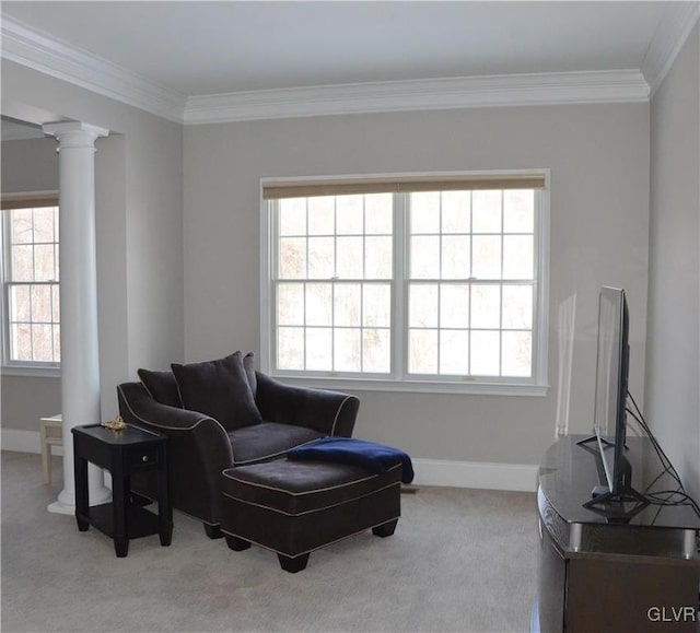 sitting room with decorative columns, crown molding, and light colored carpet