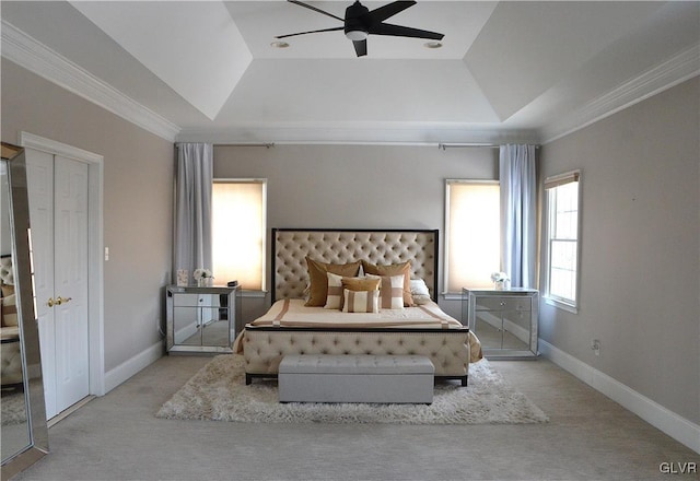 bedroom with crown molding, light colored carpet, ceiling fan, and a tray ceiling