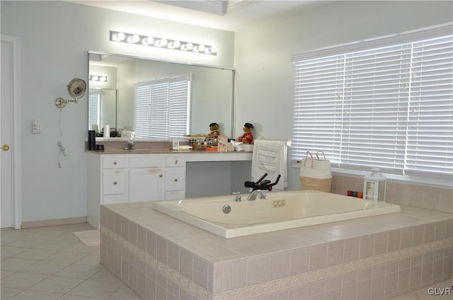 bathroom featuring vanity, a relaxing tiled tub, ornamental molding, and tile patterned floors