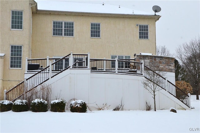 snow covered property featuring a deck