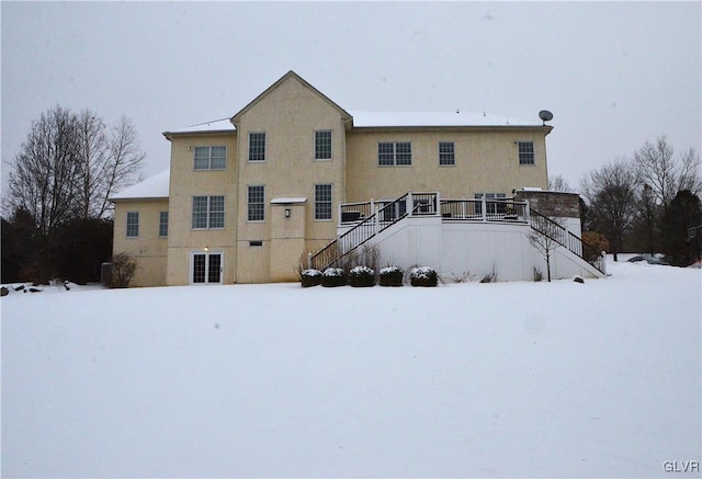 view of snow covered back of property