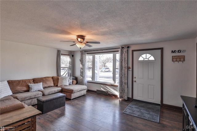 living room with ceiling fan, dark wood-type flooring, and a textured ceiling