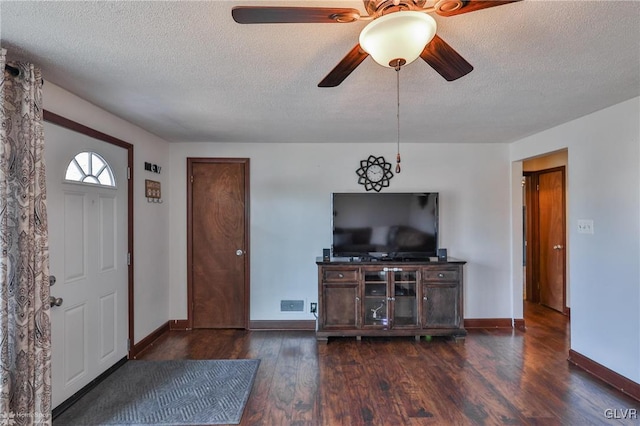 unfurnished living room with ceiling fan, dark hardwood / wood-style floors, and a textured ceiling