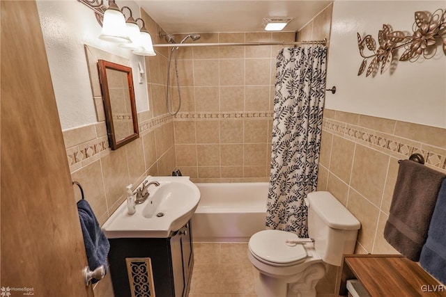 full bathroom featuring tile walls, vanity, toilet, shower / bathtub combination with curtain, and tile patterned floors