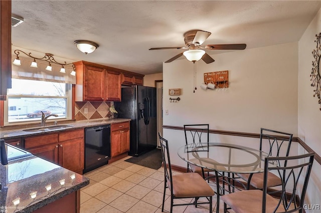 kitchen with sink, dark stone countertops, backsplash, light tile patterned floors, and black appliances