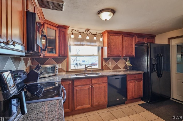 kitchen with sink, light tile patterned floors, backsplash, and black appliances