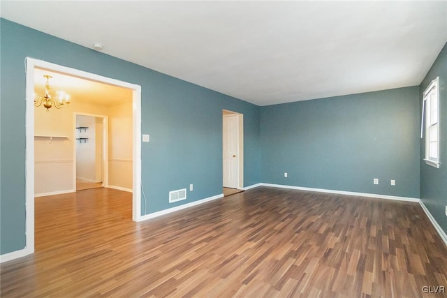 unfurnished room with hardwood / wood-style flooring and a chandelier