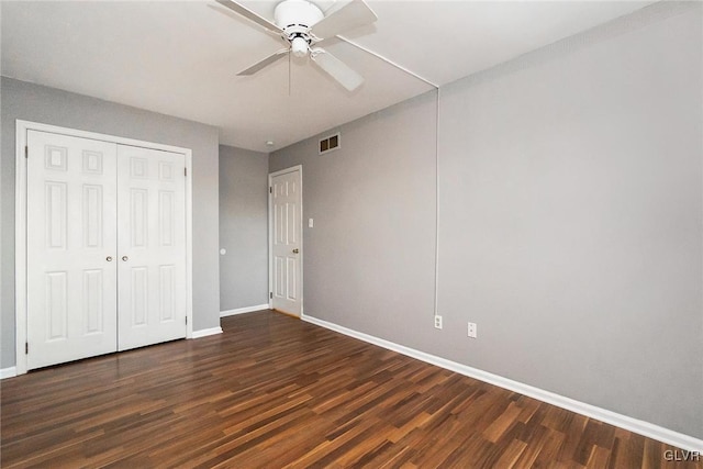 unfurnished bedroom with dark hardwood / wood-style flooring, ceiling fan, and a closet