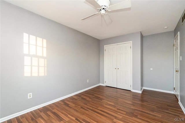 unfurnished bedroom with dark wood-type flooring, ceiling fan, and a closet