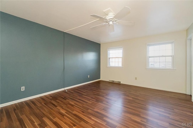 spare room featuring dark wood-type flooring and ceiling fan