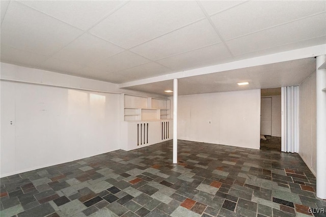 basement with a paneled ceiling