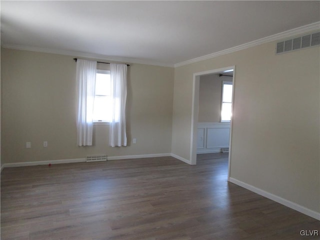 empty room with crown molding, a healthy amount of sunlight, and dark hardwood / wood-style floors